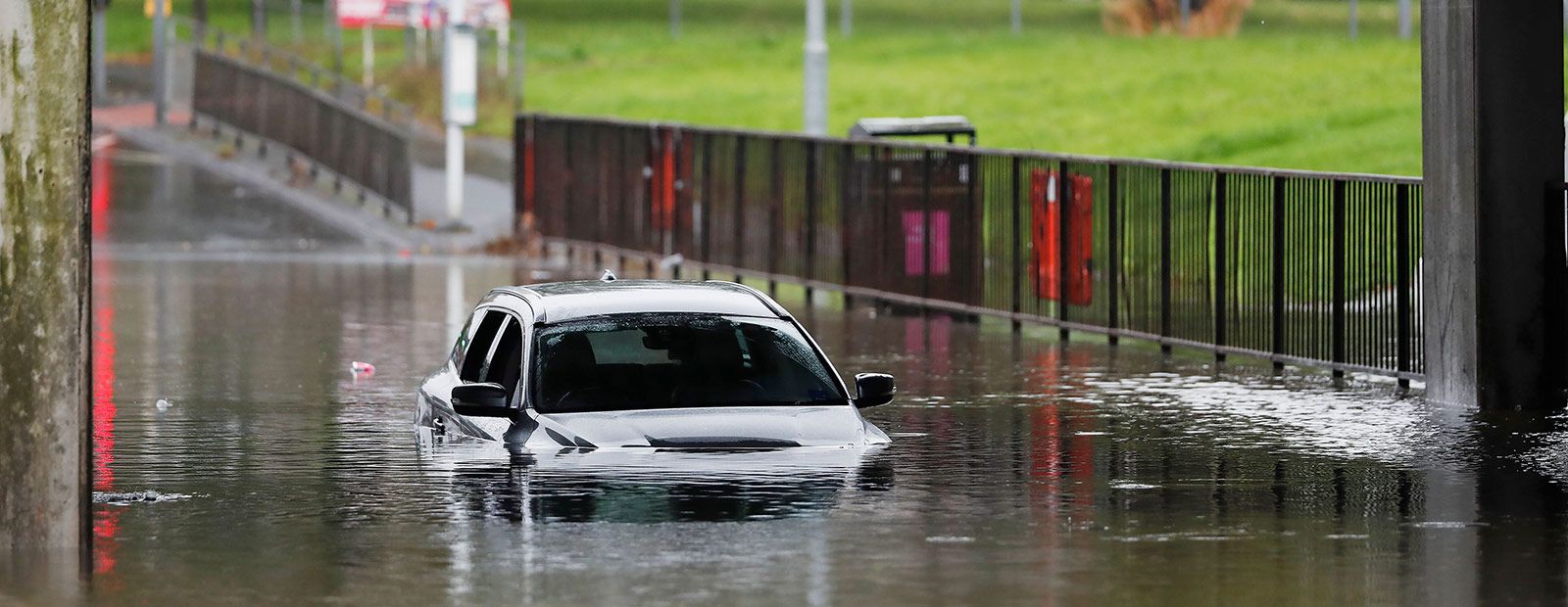 A submerged car on a flooded street banner image